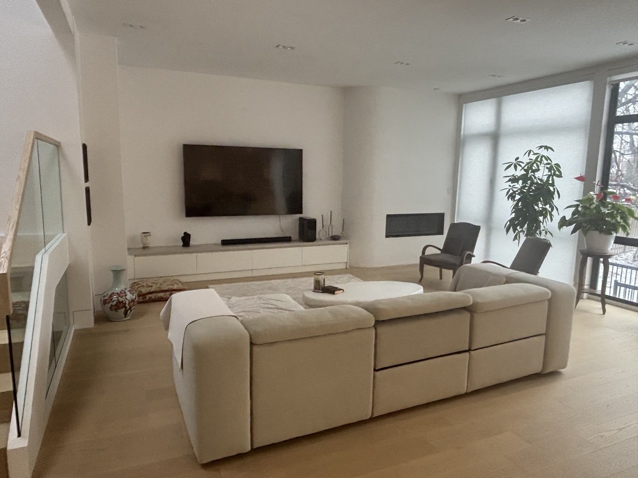 Modern open-concept living room with large windows and hardwood flooring in North York custom home